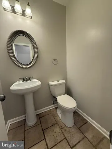 a bathroom with a toilet a sink and a mirror