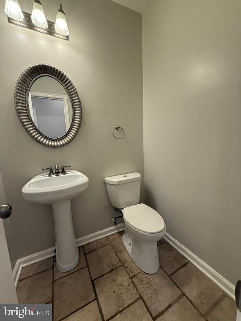 607 St Dunstans Road Baltimore, MD 21212 - Photo 12 of 25 a bathroom with a toilet a sink and a mirror