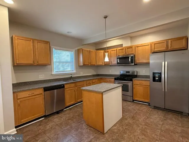 a kitchen with stainless steel appliances granite countertop a stove a sink dishwasher a refrigerator and a microwave