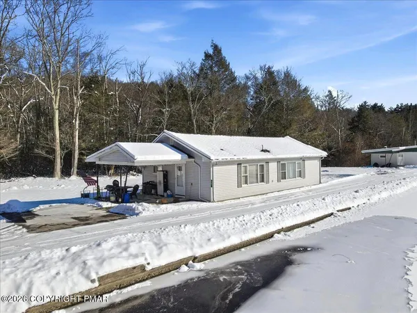 a front view of a house with a yard covered with trees