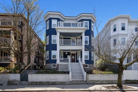 a front view of a residential apartment building with a yard
