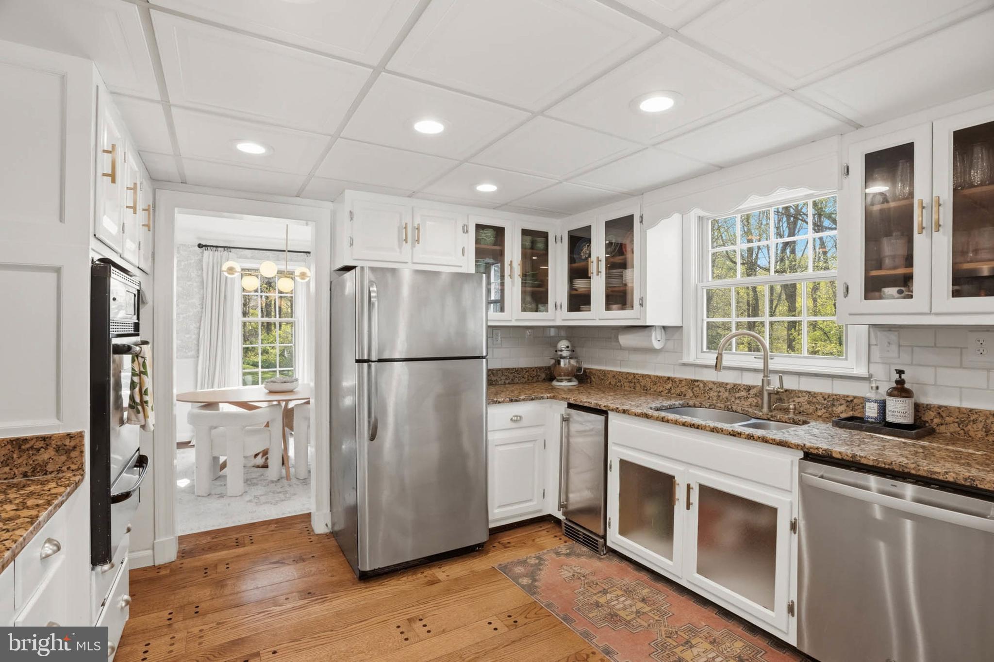 6876 Mink Hollow Road Highland, MD 20777 - Photo 10 of 61 a kitchen with stainless steel appliances granite countertop a refrigerator a sink dishwasher a stove and white countertops with wooden floor
