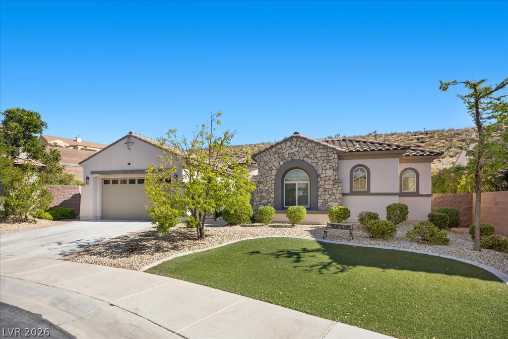 2125 De Rouge Avenue Henderson, NV 89044 - Photo 29 of 96 Stone facade and a welcoming arched entry create an inviting curb appeal to this charming residence.
