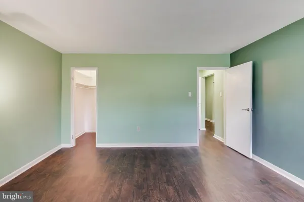 an empty room with wooden floor and closet