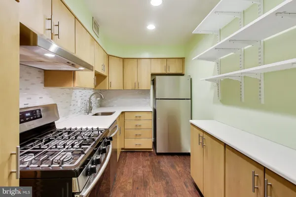 a kitchen with refrigerator a stove a sink and cabinets