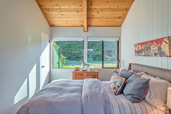 a bed sitting in a bedroom next to a window