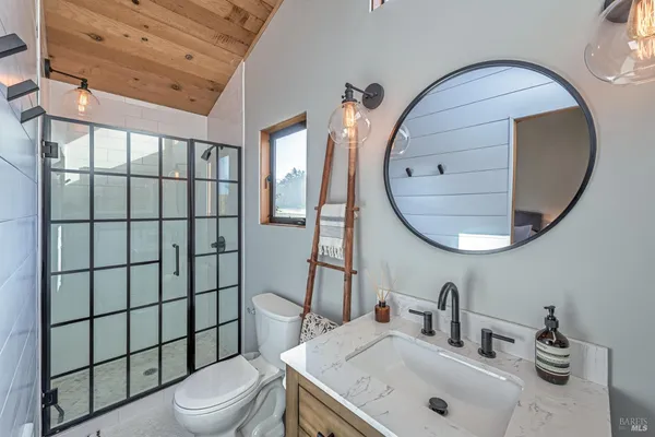 a bathroom with a sink a toilet and a mirror