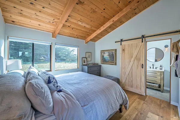 a bed sitting in a spacious bedroom next to a window
