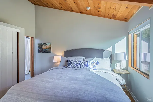 a bedroom with a large bed and wooden floor