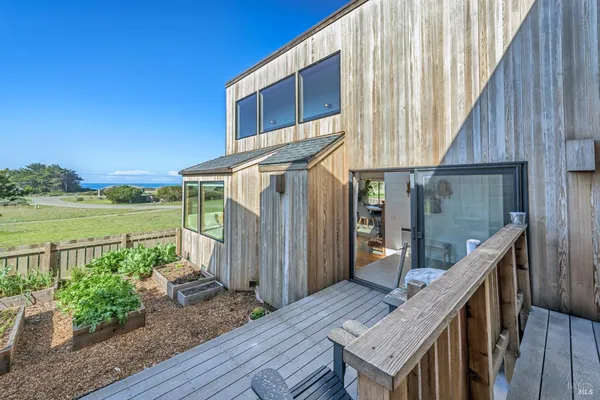 a view of a house with wooden floor next to a yard