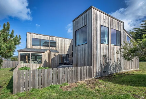 a view of house with backyard and wooden fence