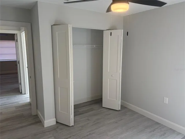 an empty room with wooden floor and closet
