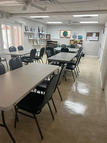 a room with furniture a air conditioner vent and a window