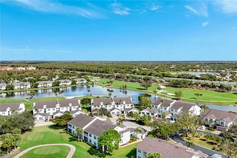 an aerial view of lake and residential houses with outdoor space