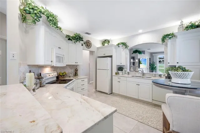 a kitchen with white cabinets and a stove