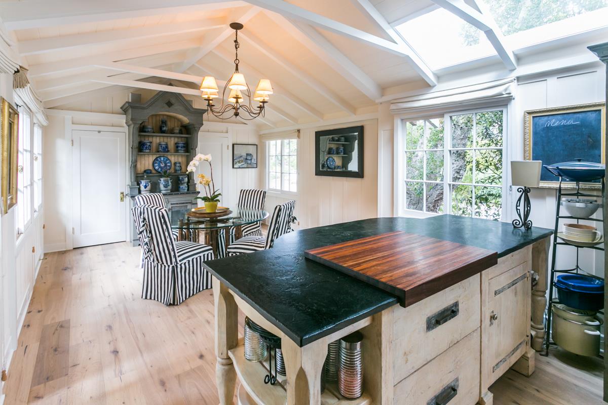 0 Camino Real Carmel, CA 93921 - Photo 9 of 27 a kitchen with stainless steel appliances granite countertop a stove top oven a dining table and chairs with wooden floor