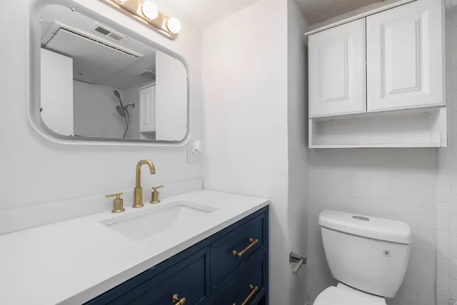 a bathroom with a toilet sink and mirror