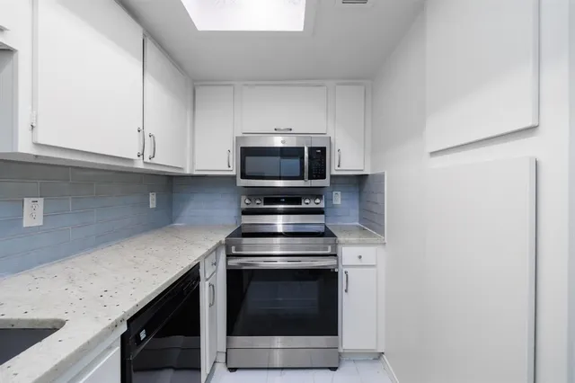 a kitchen with granite countertop a stove and a sink