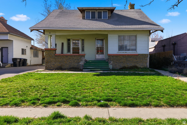 869 West Center Street Provo, UT 84601 - Photo 4 of 32 Bungalow featuring brick siding, covered porch, a front lawn, a chimney, and roof with shingles