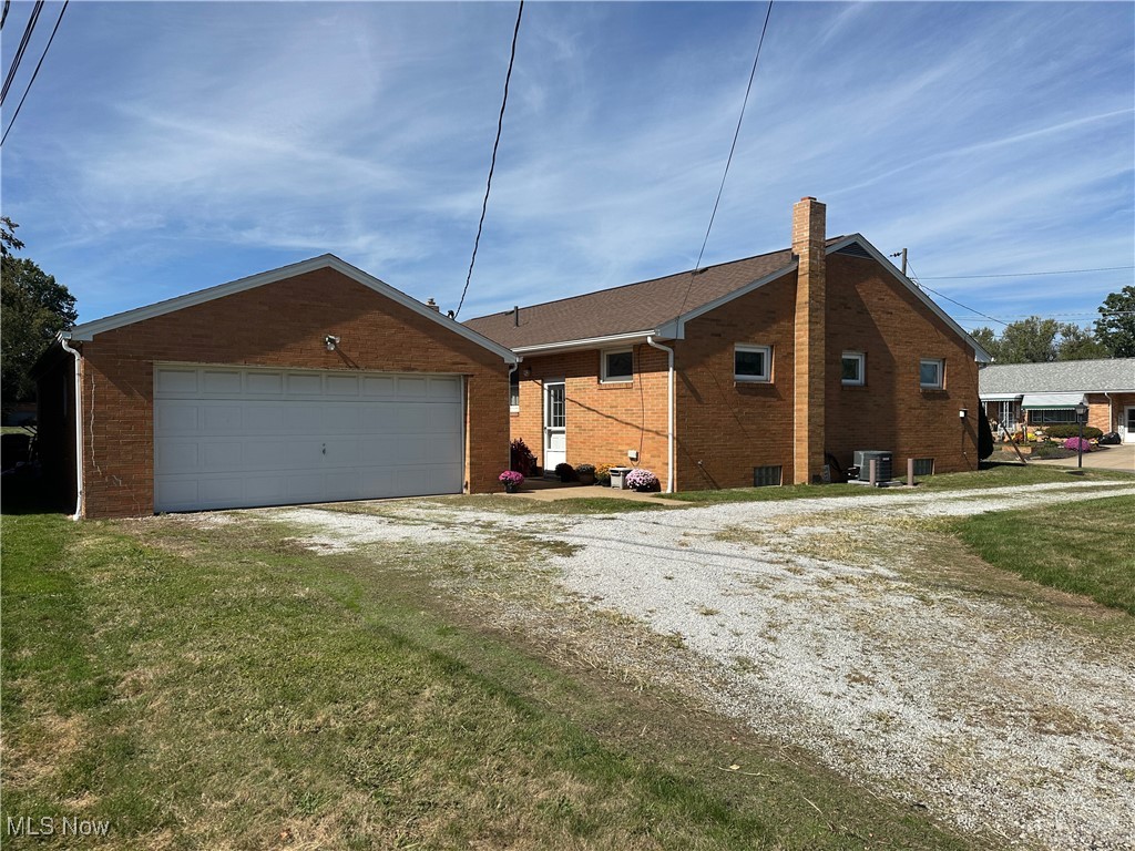 4404-4408 8th Street Northwest Canton, OH 44708 - Photo 3 of 6 View of side of home featuring brick siding, a chimney, a garage, driveway, and a yard