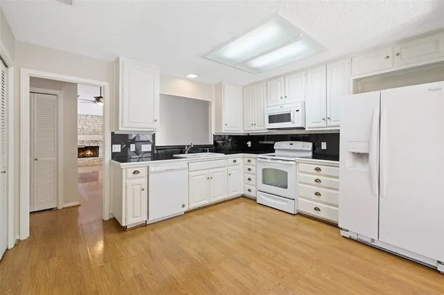 a kitchen with white cabinets and white appliances