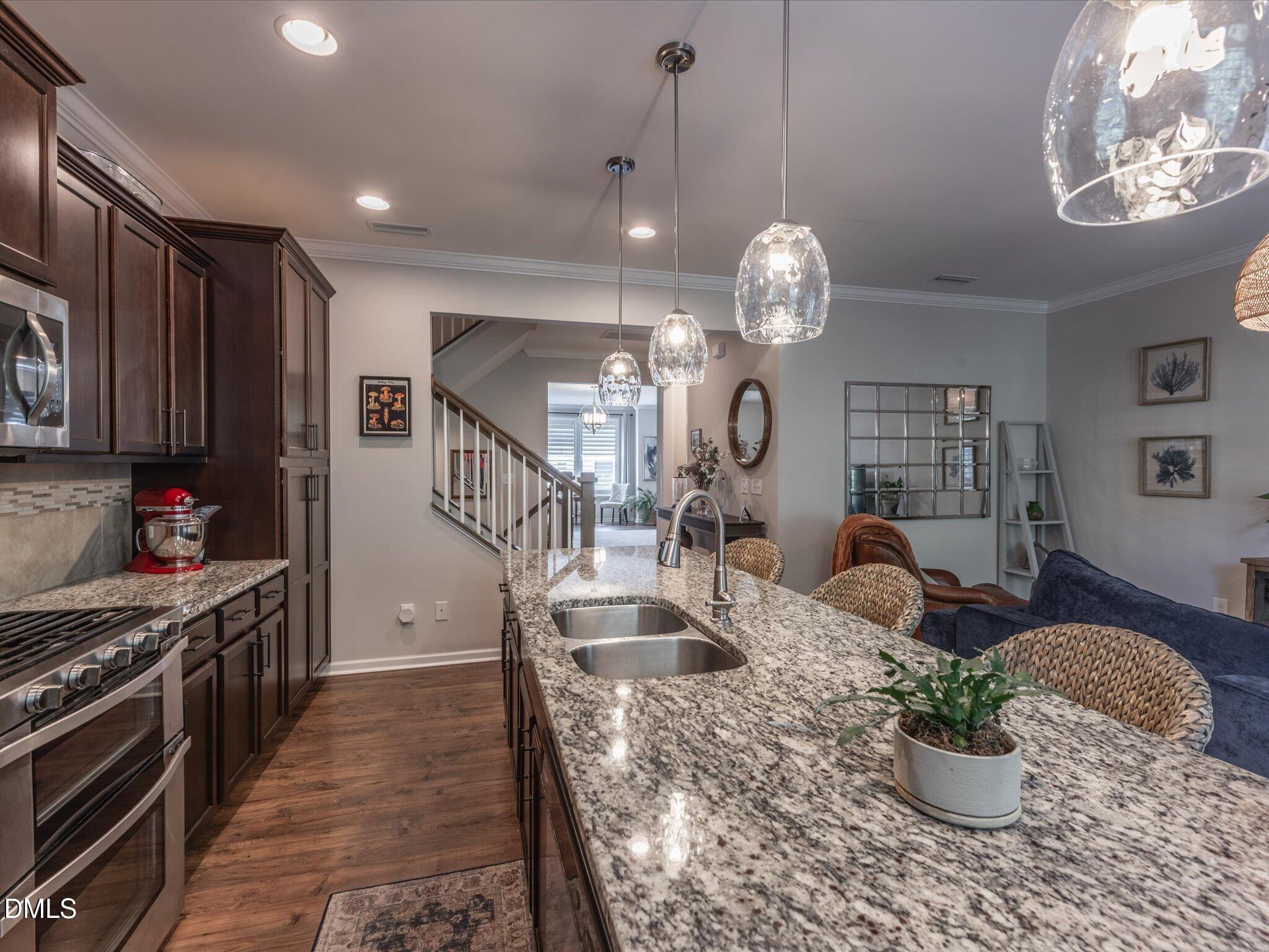 533 Metro Station Apex, NC 27502 - Photo 11 of 45 a dining room with wooden floor a chandelier a wooden table and chairs