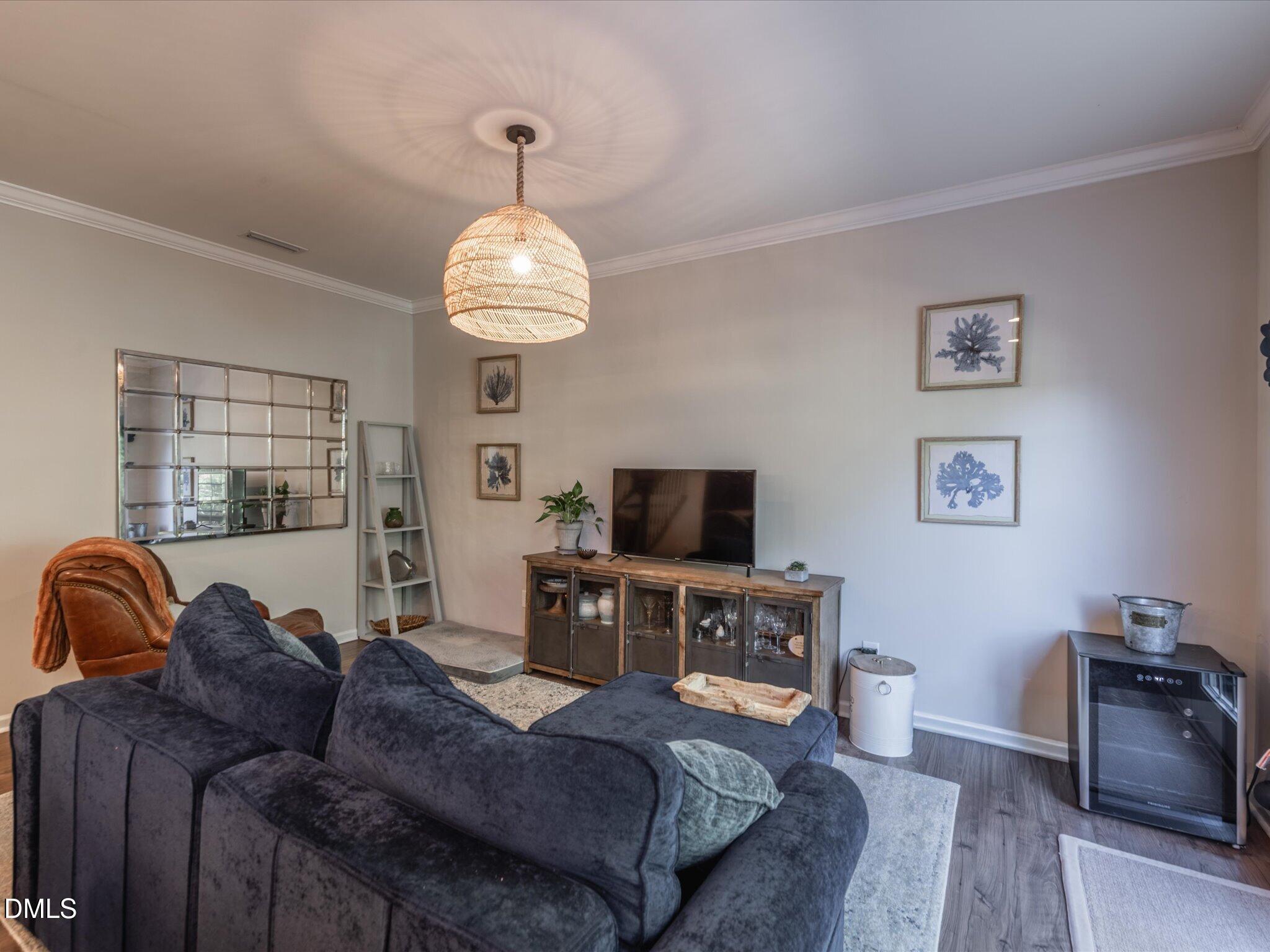 533 Metro Station Apex, NC 27502 - Photo 12 of 45 a living room with furniture a chandelier and a flat screen tv