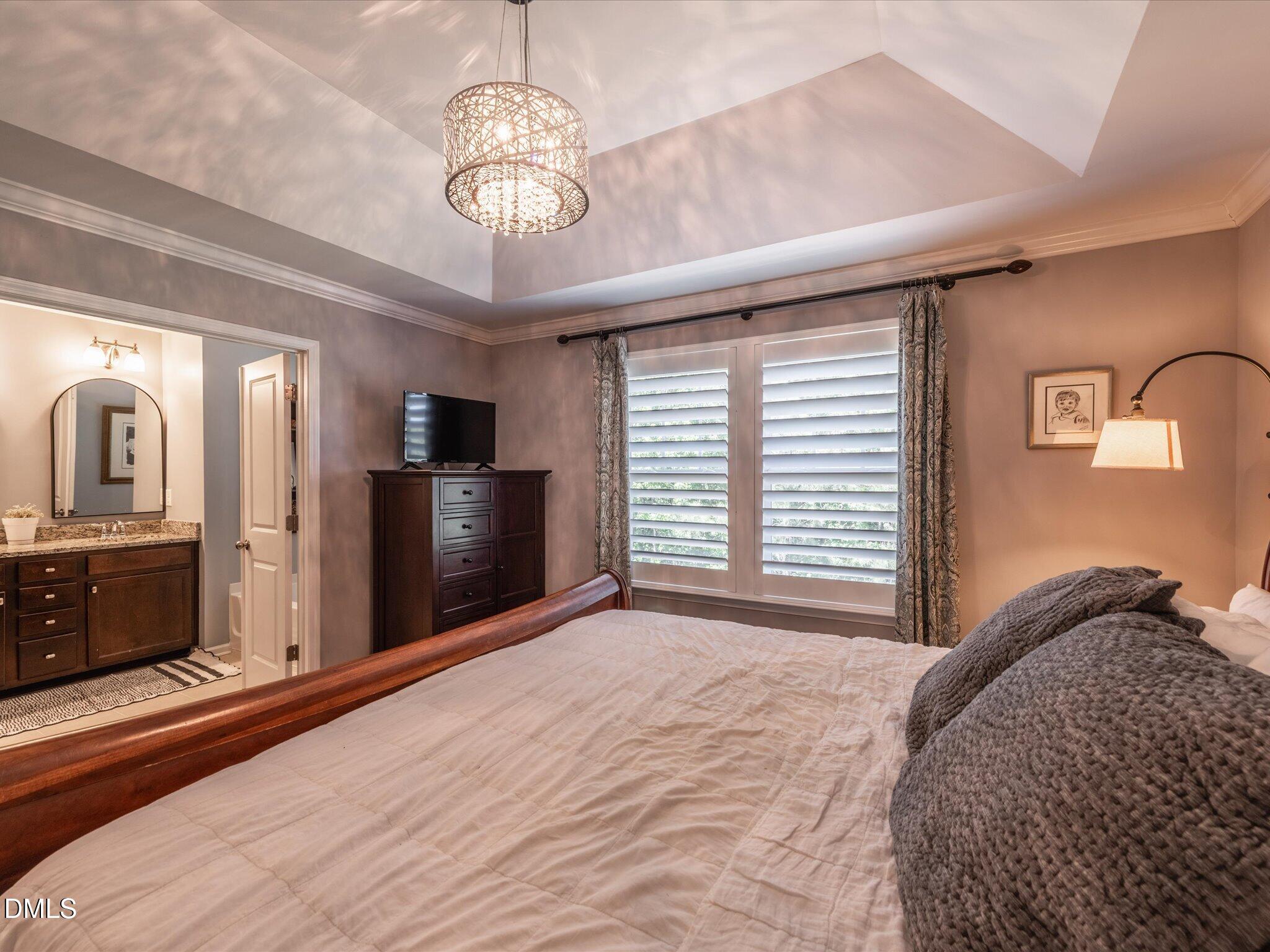 533 Metro Station Apex, NC 27502 - Photo 34 of 45 a view of a bedroom with a bed and a chandelier