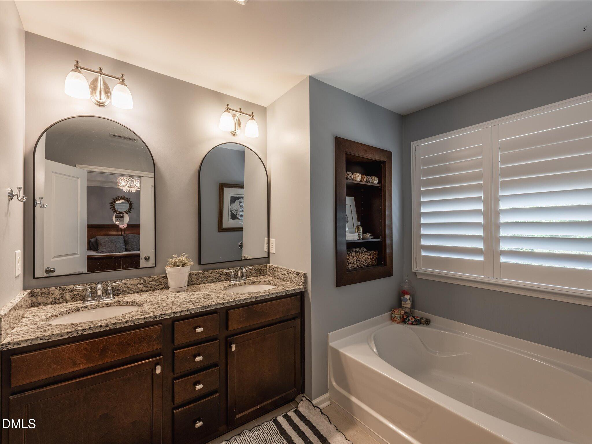 533 Metro Station Apex, NC 27502 - Photo 35 of 45 a spacious bathroom with a granite countertop sink and a large mirror