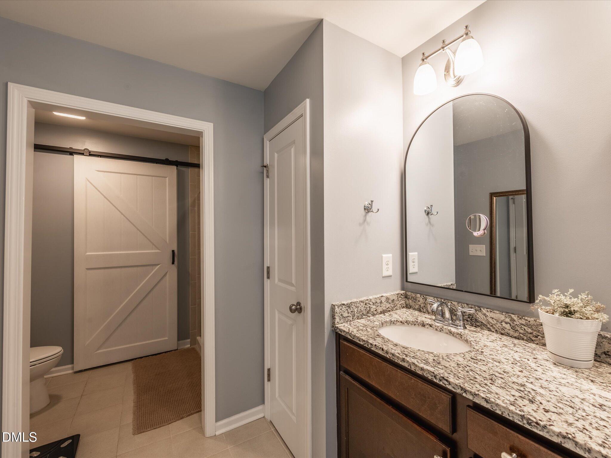 533 Metro Station Apex, NC 27502 - Photo 38 of 45 a bathroom with a granite countertop sink and a mirror