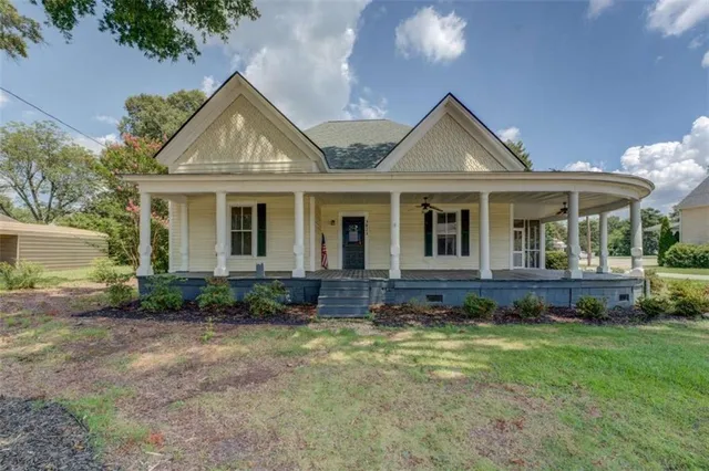 a view of house with yard and outdoor seating