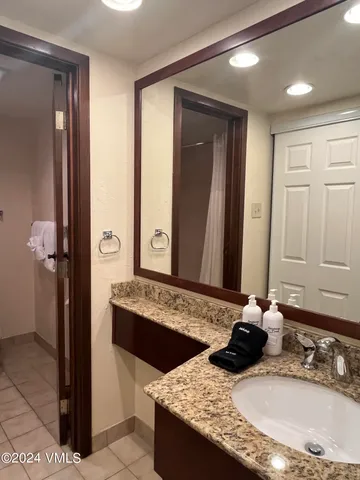 a bathroom with a granite countertop sink and a mirror