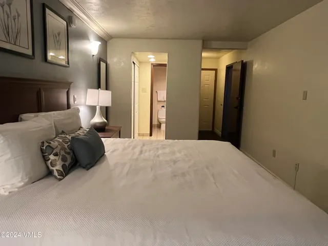 a bed room with a bed mirror and a night stand