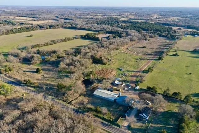 a view of a backyard with table and chairs under an umbrella