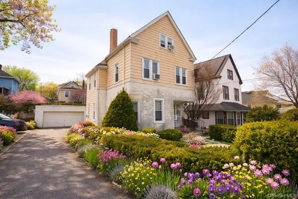 a front view of a house with a yard and fountain