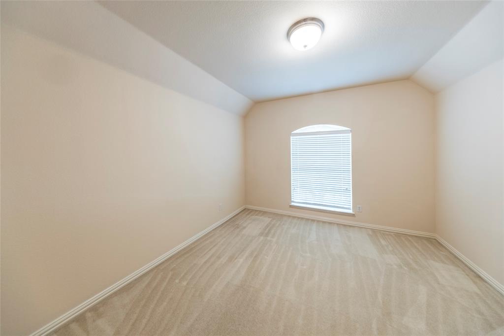 220 Justin Road Murphy, TX 75094 - Photo 32 of 40 Empty room featuring vaulted ceiling, light colored carpet, and baseboards