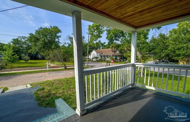 a view of a porch with a floor to ceiling window next to a yard