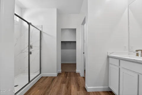a view of hallway with a sink and wooden floor