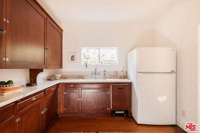 a kitchen with a sink a refrigerator and cabinets