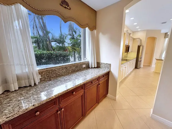a large kitchen with stainless steel appliances kitchen island granite countertop a large counter top a stove a sink and a refrigerator