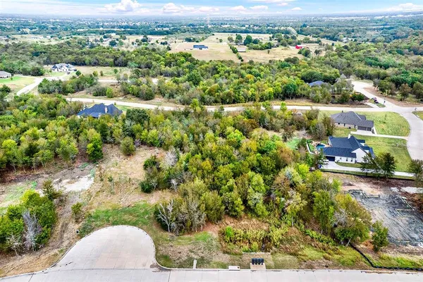 an aerial view of residential houses with outdoor space and trees