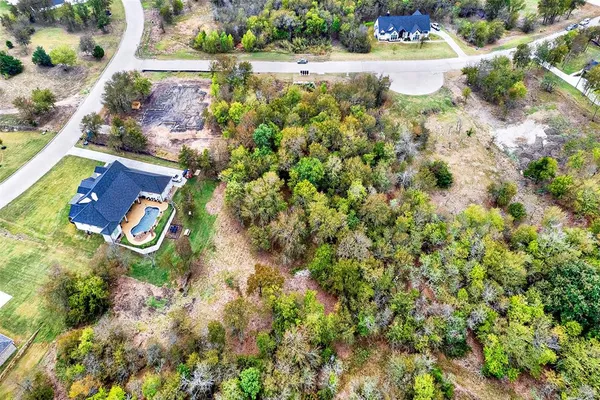 an aerial view of a house with a yard and large trees
