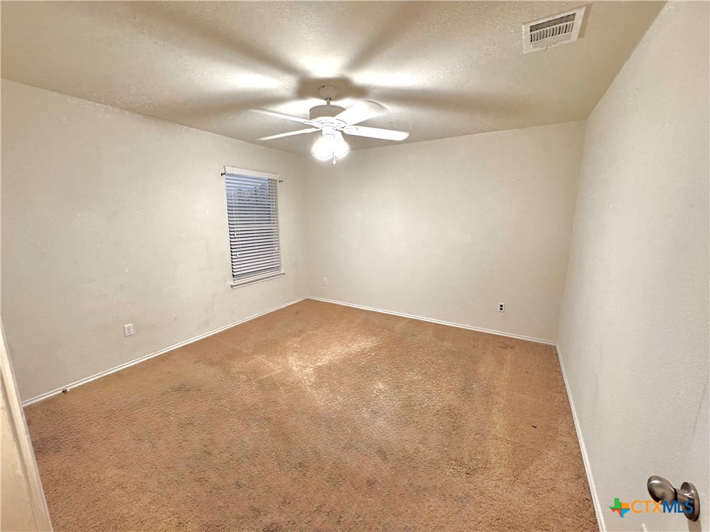 3101 Shawlands Road Killeen, TX 76542 - Photo 38 of 45 an empty room with a chandelier fan and windows