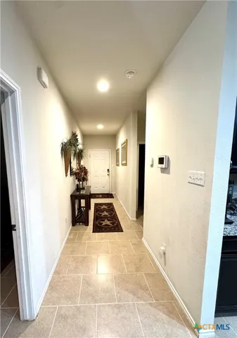 a view of a hallway and a livingroom with furniture
