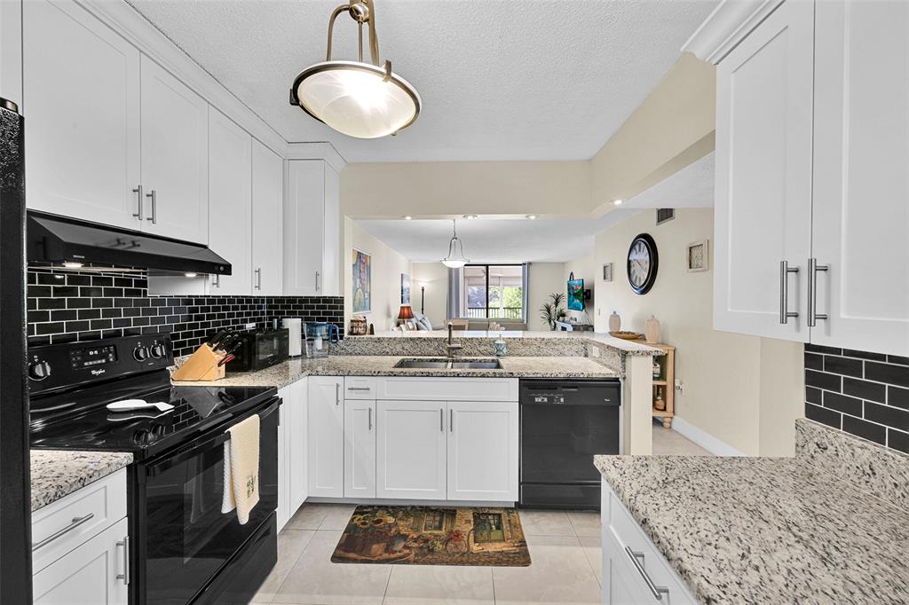 3591 Environ Boulevard, Unit A305 Lauderhill, FL 33319 - Photo 14 of 73 a kitchen with stainless steel appliances granite countertop a stove sink and cabinets