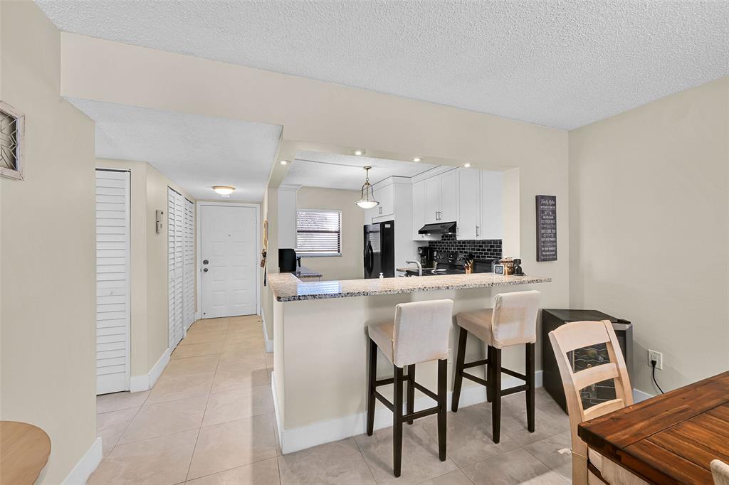 3591 Environ Boulevard, Unit A305 Lauderhill, FL 33319 - Photo 18 of 73 a kitchen with a sink and chairs