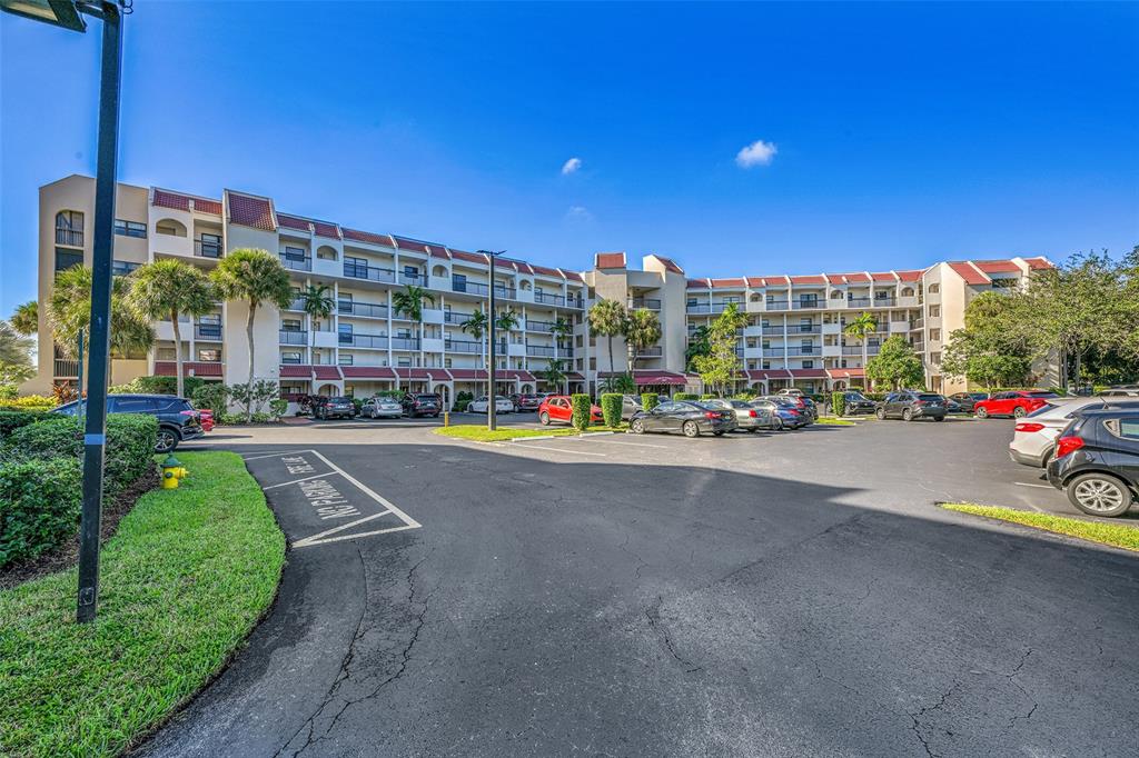 3591 Environ Boulevard, Unit A305 Lauderhill, FL 33319 - Photo 2 of 73 a view of a city street with a building and cars park