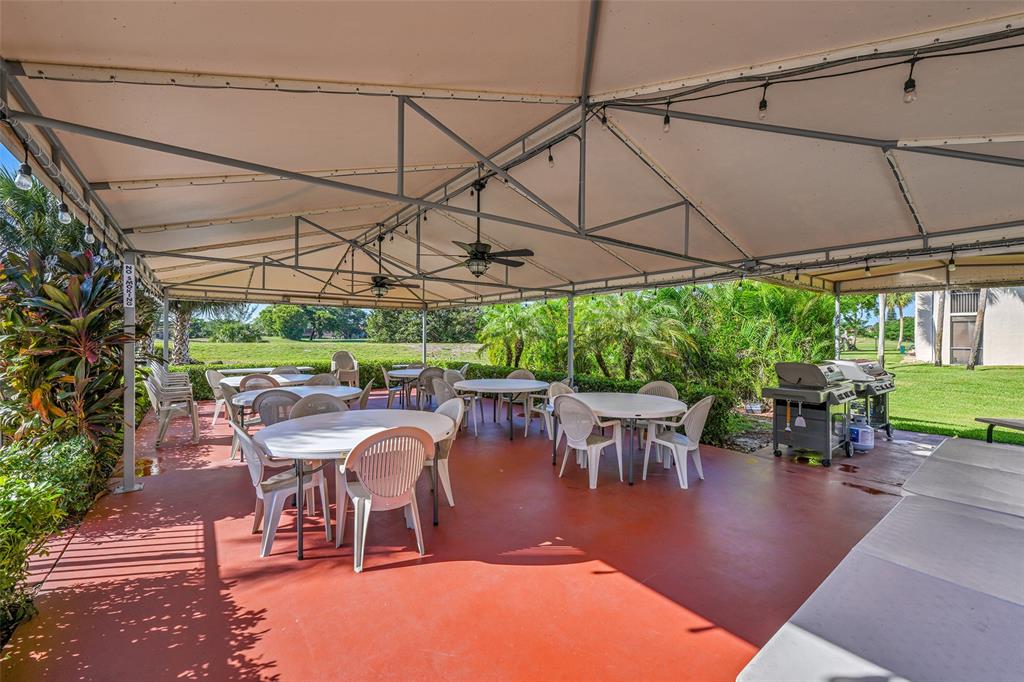 3591 Environ Boulevard, Unit A305 Lauderhill, FL 33319 - Photo 42 of 73 a patio with a patio table and chairs