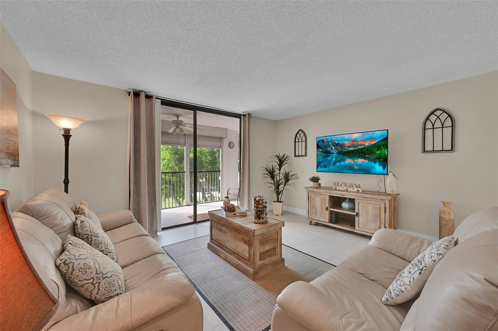 3591 Environ Boulevard, Unit A305 Lauderhill, FL 33319 - Photo 8 of 73 a living room with furniture and a flat screen tv