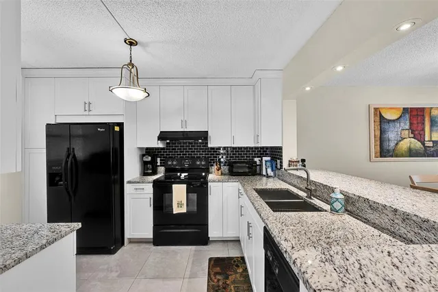 a kitchen with stainless steel appliances granite countertop a stove sink and cabinets
